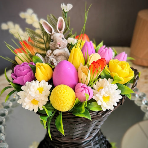 Spring Easter basket arrangement featuring a bunny soap surrounded by colorful flower soaps and a central egg soap, with decorative greenery and accents.