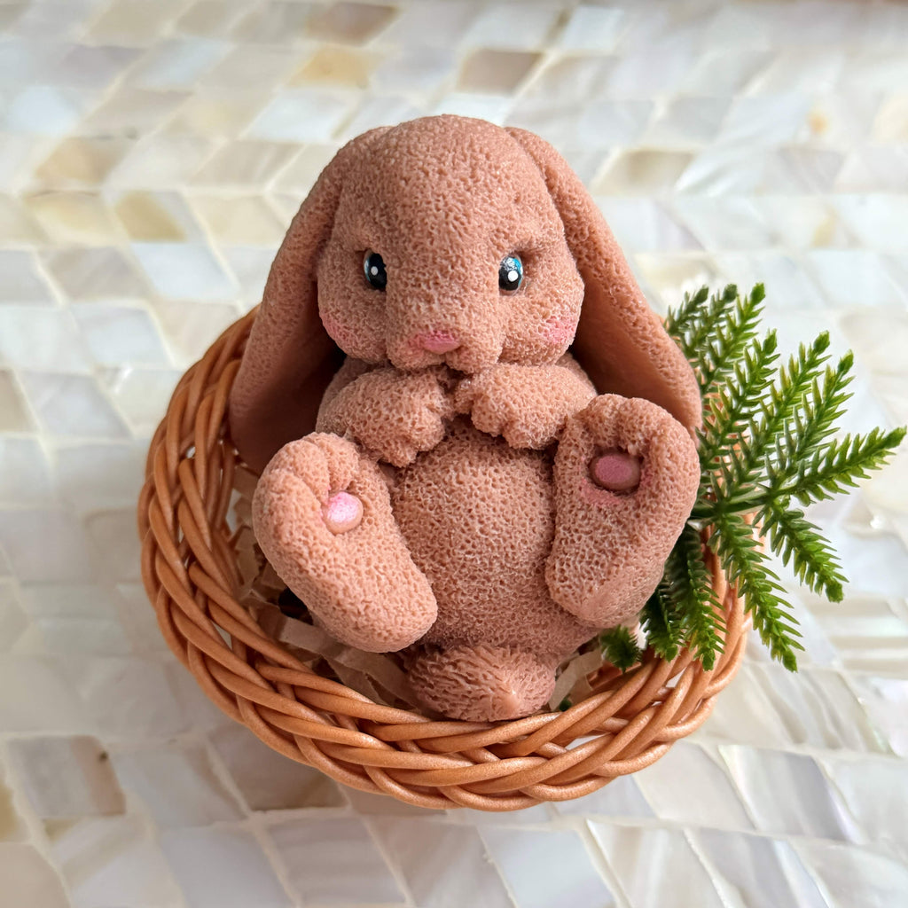 Plush bunny toy in a woven basket on a textured surface
