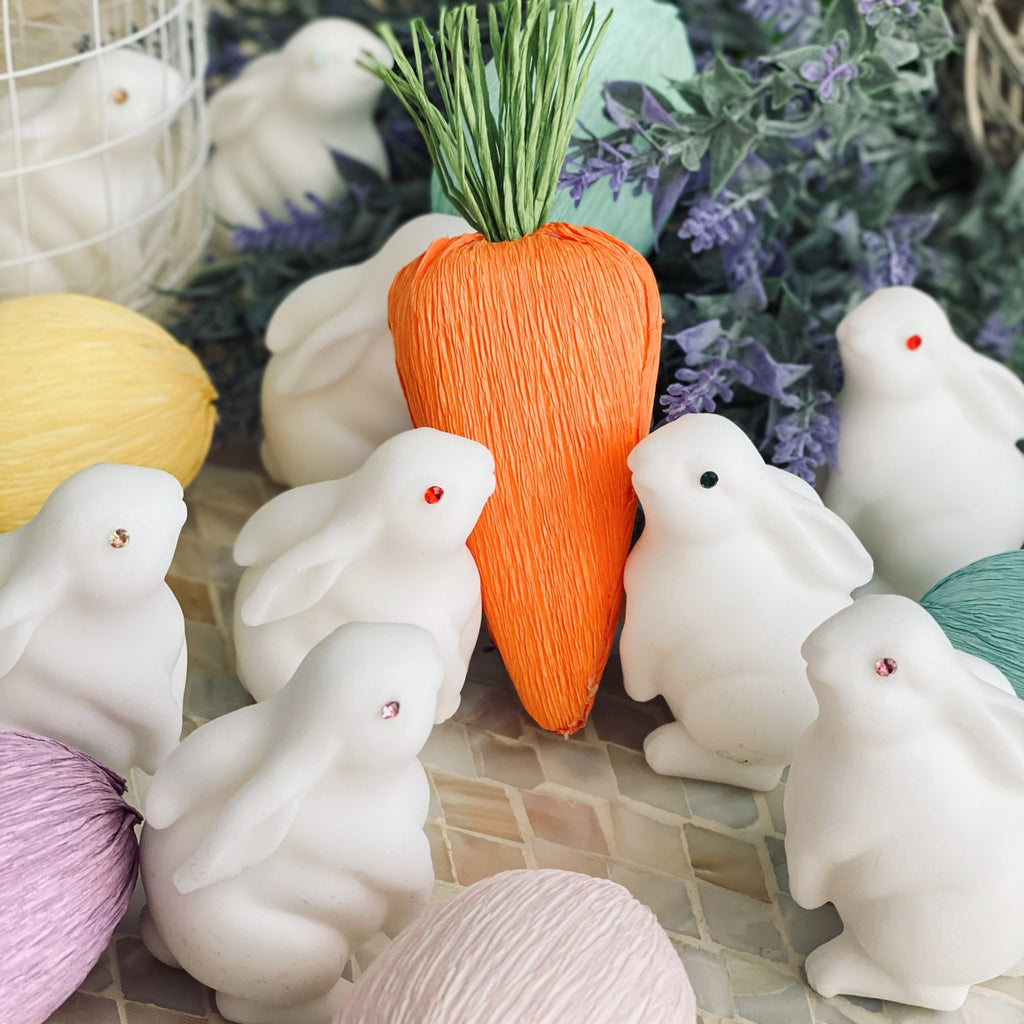Decorative carrots and rabbits on a tiled surface with a floral background
