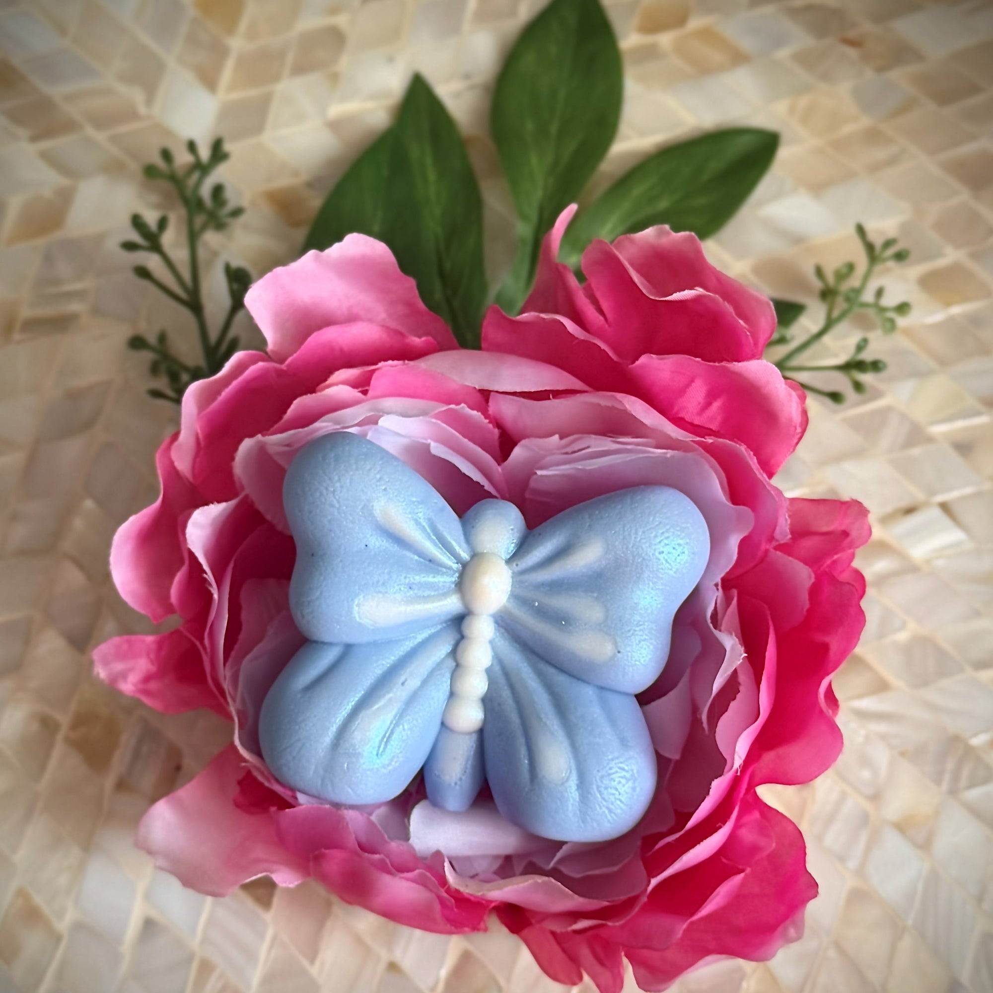 Pink flower with a blue butterfly on a textured beige background